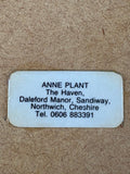 Contact label for Anne Plant on reverse of ceramic wall hanging.