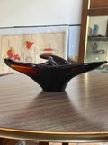 Side view of amber Murano glass bowl with sculptural curves.