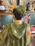 Detailed view of the back of the cap and coat, showing hand-painted glaze variation and sculpted folds.