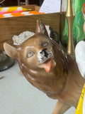 Close-up of the Wolf’s head from the figurine, with a slightly comical expression, protruding tongue, and fine painted detail on the fur and face.