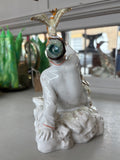 Back view of the figurine showing Ivan’s seated position, arm raised to hold the bird, with a swirl of white glaze suggesting motion or cloud.