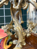 Close-up showing intricate floral motifs on the stem of a Rococo style brass candelabra