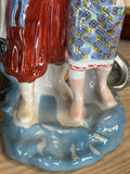Detail of base of figurine, showing traditional Ukrainian clothing and blue glaze