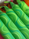 Green and lime marbled taper candles with swirled patterns.
