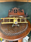 Front view of yellow Nieuport 17 biplane model showing rotary engine cowling and red propeller