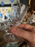 Close-up of Georgian cordial glass held up showing fern engraving detail