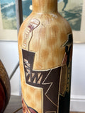 Close-up of Art Deco figure in suit and hat moulded onto ceramic bottle body.