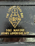 Close-up of gold maker’s stamp on black lacquered interior of Henry Loveridge cash box reading The London Cash Box Sole Makers Henry Loveridge and Co within a diamond cartouche