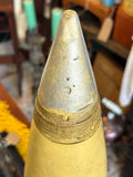 Close-up of grey ogive nose of Soviet artillery shell replica showing stamped Cyrillic-style markings and inspection stamp