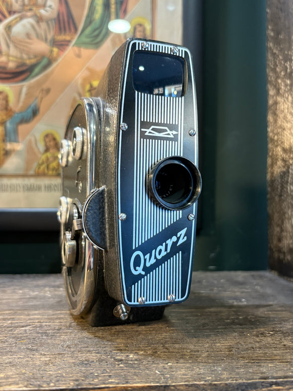Angled front view of vintage USSR Quarz 8mm movie camara with striped faceplate