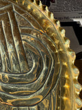Detail of the hammered border and pie crust rim of an Arts and Crafts brass dish, with light spotting