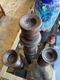 Set of three candle holders side by side on glass counter seen from above 