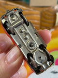 Underside of US-Zone Germany tin litho toy car showing pressed steel chassis and steering mechanism