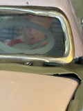 Close-up of driver figure visible through car windscreen