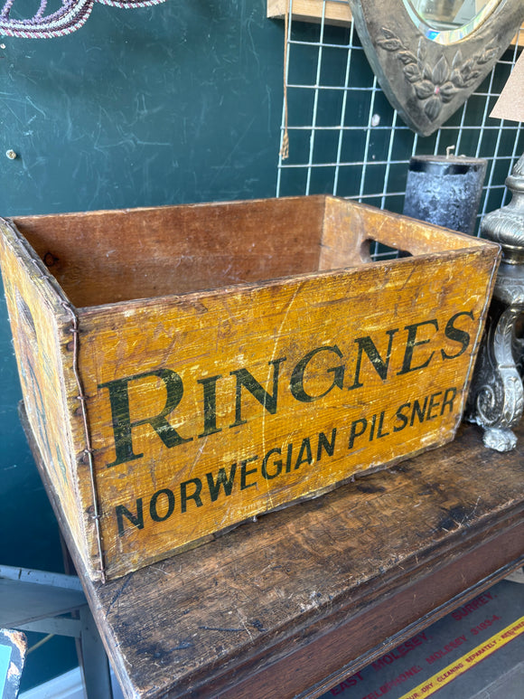 Vintage wooden Ringnes beer crate with bold black lettering and side handles. 