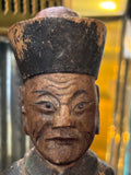 Close-up of lined, painted face on antique Chinese carved wood official figure