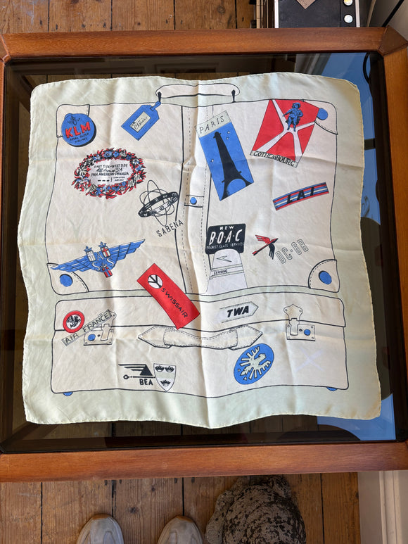 1950s silk scarf with suitcase design and vintage airline logos on pale green background