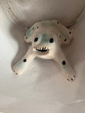 Close-up of the sculpted ceramic frog figure inside an antique Staffordshire surprise mug