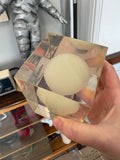 Top view of hand-held Giraudon resin cube showing the dome of the frosted lightbulb centred within the block.