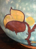 Close-up of textured turquoise glaze and hand-painted leaves