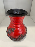 Front view of red and black fat lava pottery vase showing flared neck and bulbous body