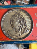 Close-up of embossed Queen Victoria portrait on chocolate tin