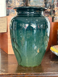 Reverse of an English art pottery vase in graduated green glaze with a trailing painted stem