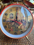 Close-up of alarm clock face showing Mao Zedong portrait and revolutionary crowd scene