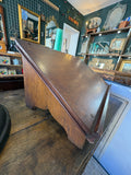 Side view of vintage oak lectern showing sloped top and shaped wooden apron