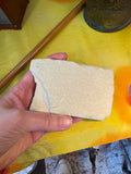 Reverse of Knightia fossil fish matrix held in hand showing plain pale cream and buff coloured limestone shale reverse with natural irregular edges
