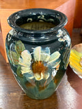 Top view of an English art pottery vase showing the rolled rim and glossy dark green glaze