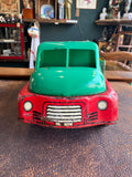 Front-on view of Wells-Brimtoy tinplate toy truck showing printed red grille and headlights and green cab