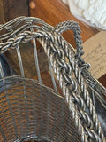Close-up of twisted wire handle join and woven rim