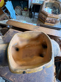 Overhead view looking down into the interior of the mustard yellow glazed planter on the ceramic tiger’s back, showing the glazed interior, drainage holes through to the body, and the rim of the saddle planter.