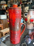 Mid-century studio pottery jug with lid, red drip glaze, front view
