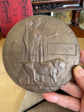 WWI memorial plaque held in hand showing lion and Britannia design