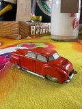 Rear three-quarter view of red post-war tin litho toy car showing Made in US-Zone Germany marking on boot