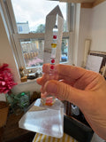 Plexiglass lighthouse souvenir held in hand, side view