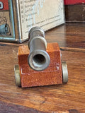 Close-up of miniature cannon muzzle showing turned brass barrel