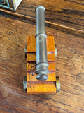 Top-down view of hand-made miniature cannon on wooden carriage