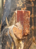 Close-up of hand holding red tablet on antique Chinese ancestor figure