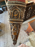 Close-up of the scabbard’s pointed chape, decorated with a temple motif enclosing a bird, and a robed figure below.