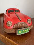 Front three-quarter view of a 1950s Gescha R-558 red tinplate Porsche 356 toy car with green Western Germany licence plate