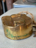 Angled view of vintage padlock, showing green patination on brass