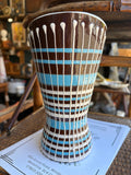 Full length view of brown and blue striped vase with white drip glaze