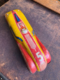 Top view of vintage JBP 501 tinplate racing car showing red yellow and blue lithography and driver panel detail