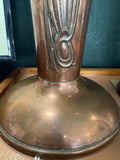 Base and lower stem of copper Art Nouveau vase showing curling tendril detail