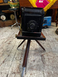 Antique bellows camera front view showing lens and wooden frame