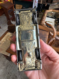 Underside of vintage Japanese tinplate ambulance toy showing pressed base and four rubber tyres