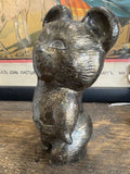Side profile of Misha bear mascot figurine, bronze finish